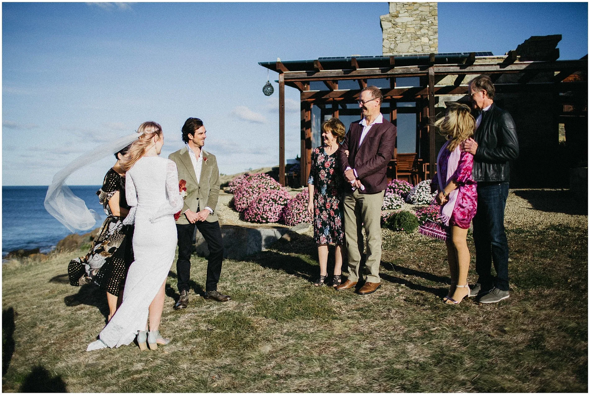 A veil lifting in the wind at a clifftop coastal ceremony
