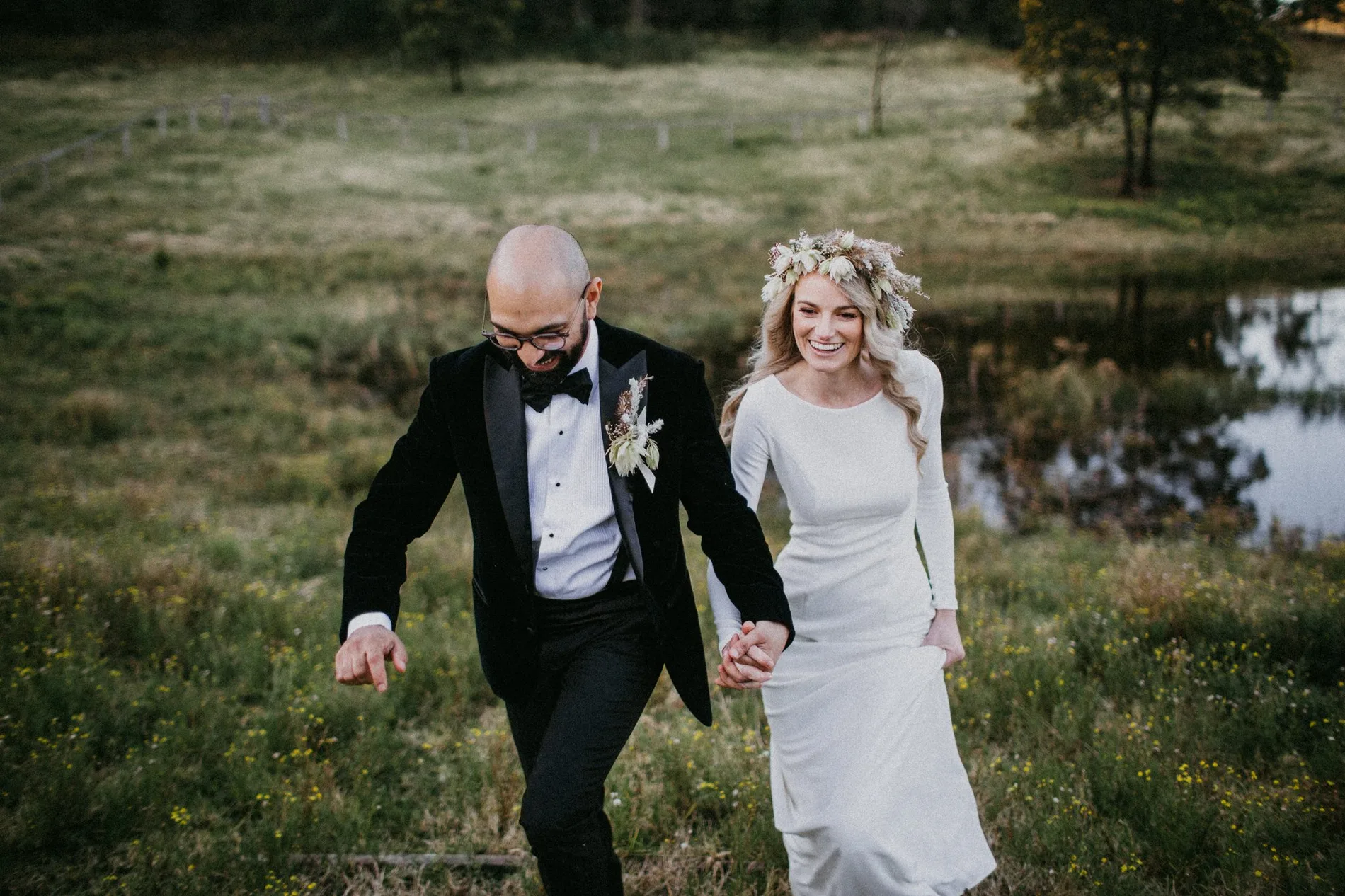 A couple walking hand in hand across a paddock