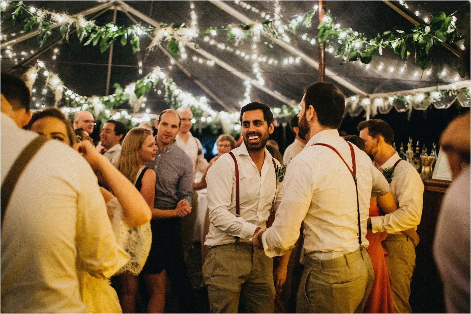 Guests laughing together under festoon lights