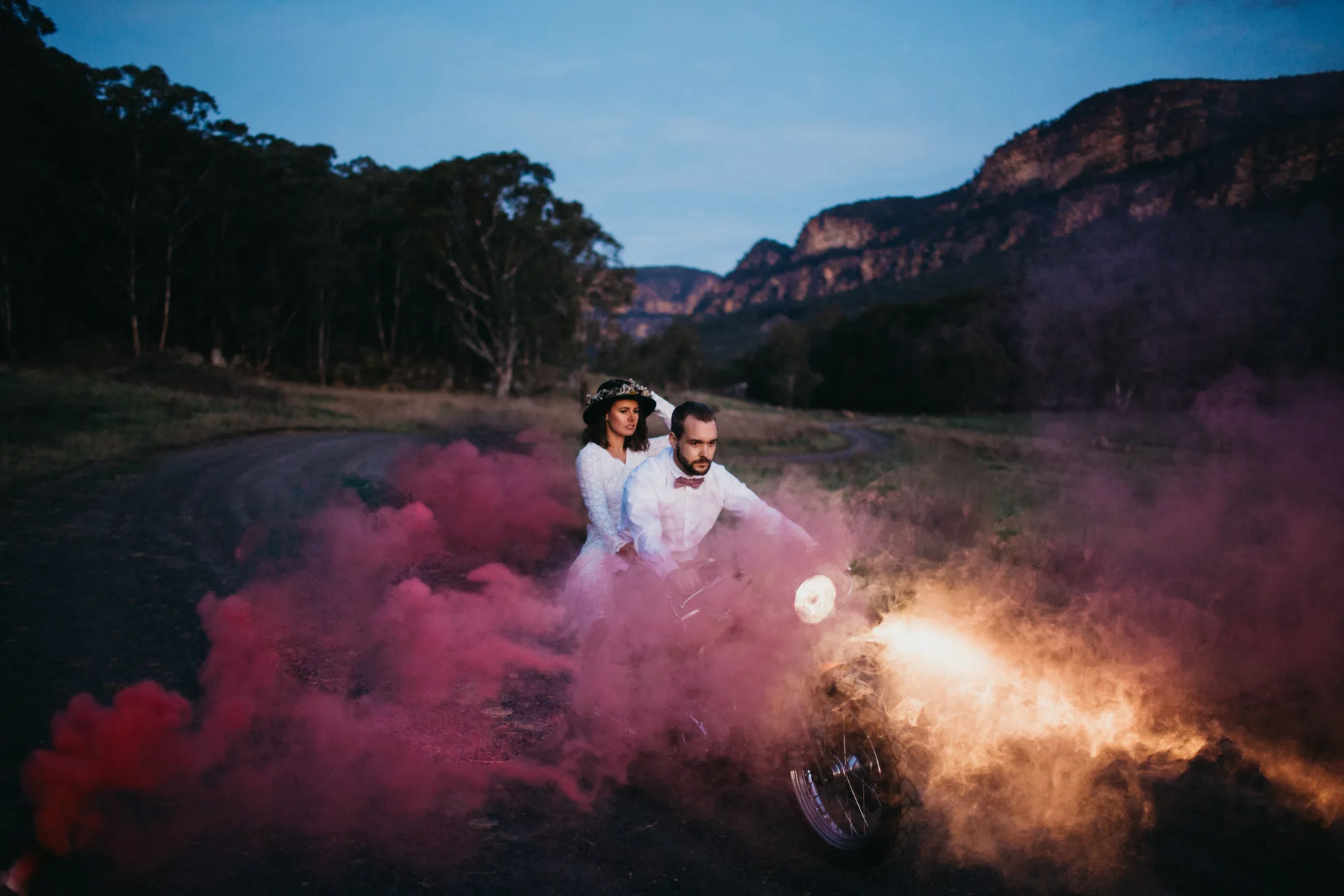 Couple in a cloud of coloured smoke on a clifftop