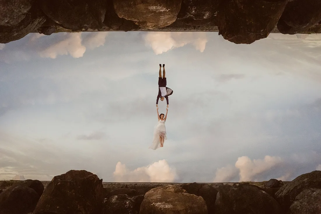 Couple reflected upside down in a still rock pool