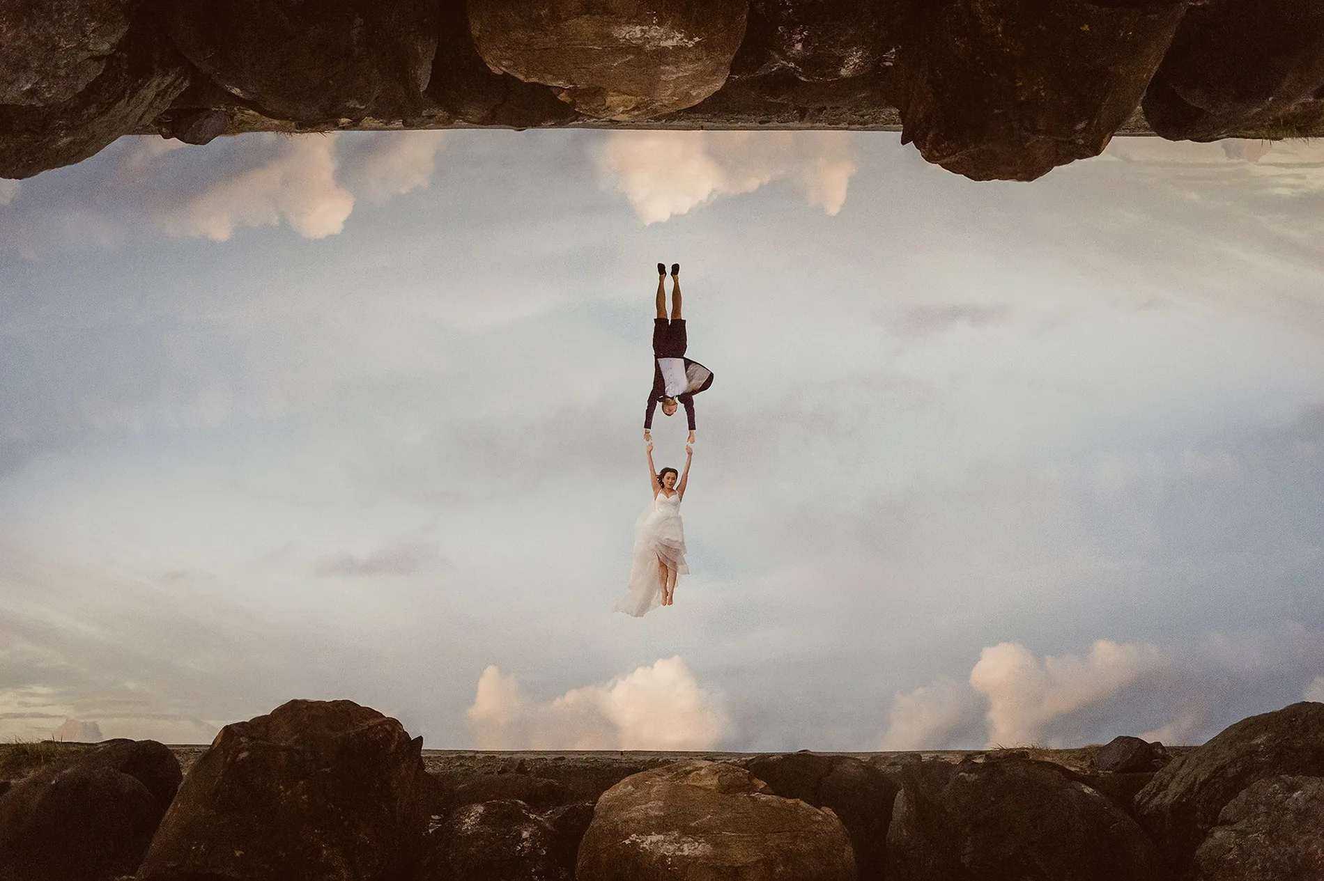 A couple reflected upside down in a still rock pool